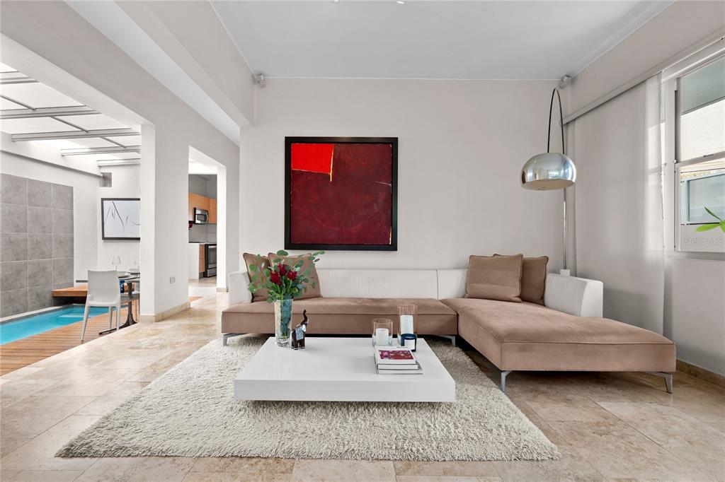 A living room with a beige sectional sofa, white coffee table, and an indoor pool area — 609 MIRAMAR AVENUE UNIT 102, SAN JUAN, PR