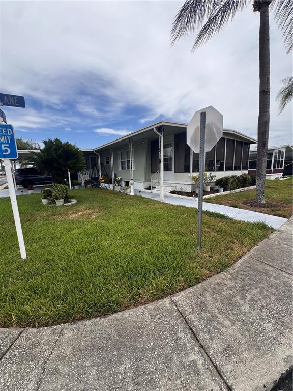 A light-colored manufactured home features a screened-in porch and a palm tree in the yard — 225 DIXIE LANE, TARPON SPRINGS, FL