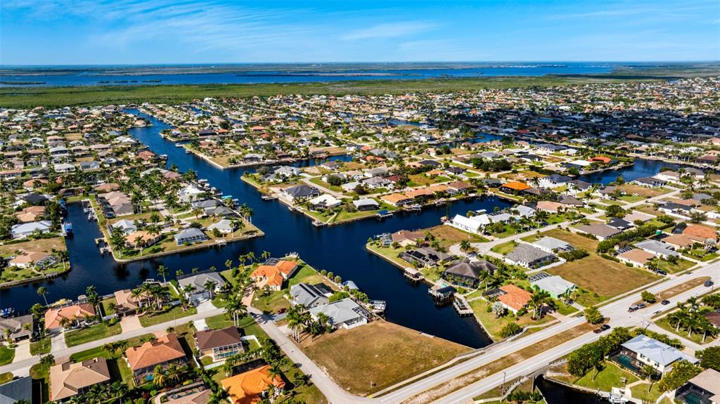 An aerial view shows a residential neighborhood with houses situated along interconnected canals — 2503 SW 41ST STREET, CAPE CORAL, FL