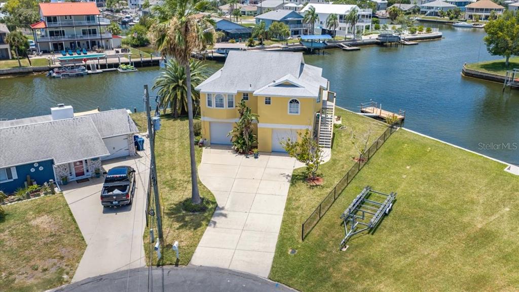 An aerial view shows a waterfront house on a corner lot with a private dock — 4365 4TH ISLE DRIVE, HERNANDO BEACH, FL