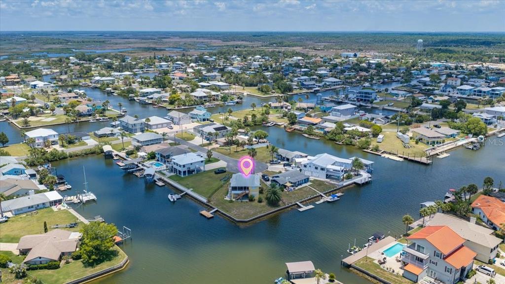A kitchen features white cabinets, granite countertops, a stainless steel refrigerator, and a breakfast bar — 4365 4TH ISLE DRIVE, HERNANDO BEACH, FL