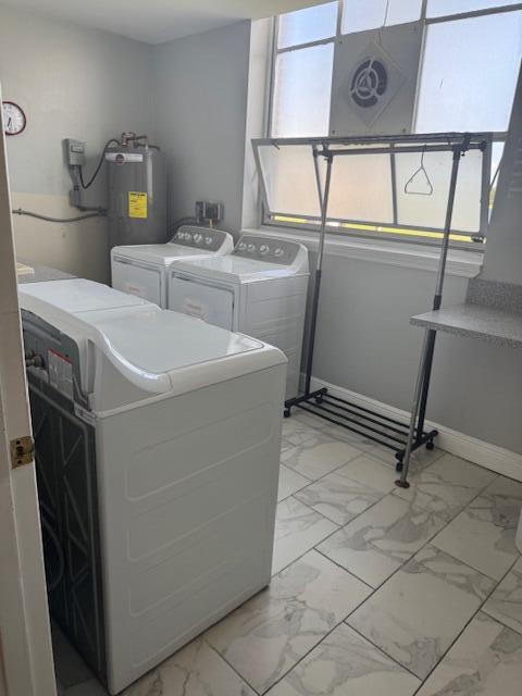 A laundry room features white appliances, a rolling garment rack, and light-colored marble-patterned tile flooring — 169 Atlantis Blvd Boulevard # 206, Atlantis FL 33462, ATLANTIS, FL