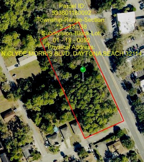 This aerial map shows a wooded, rectangular parcel of land outlined in red — 650-700 N CLYDE MORRIS BOULEVARD, DAYTONA BEACH, FL