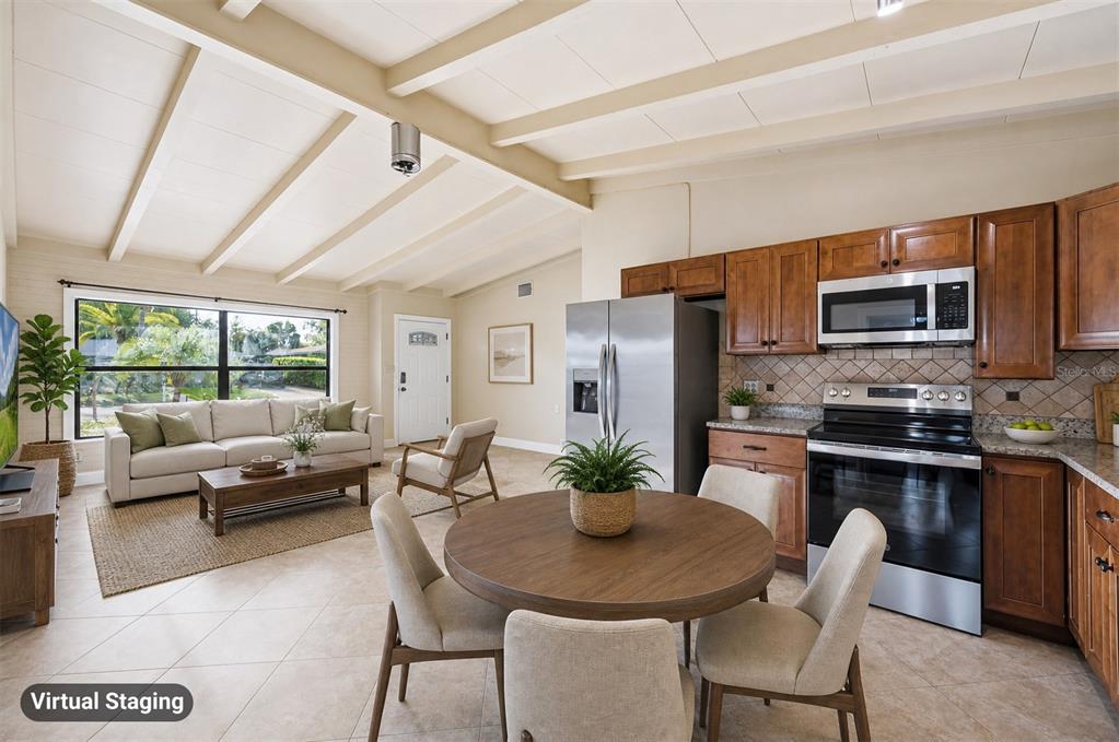 A living room and kitchen with vaulted ceilings, tile floors, and wood cabinetry — 2715 INGOT PLACE, SARASOTA, FL
