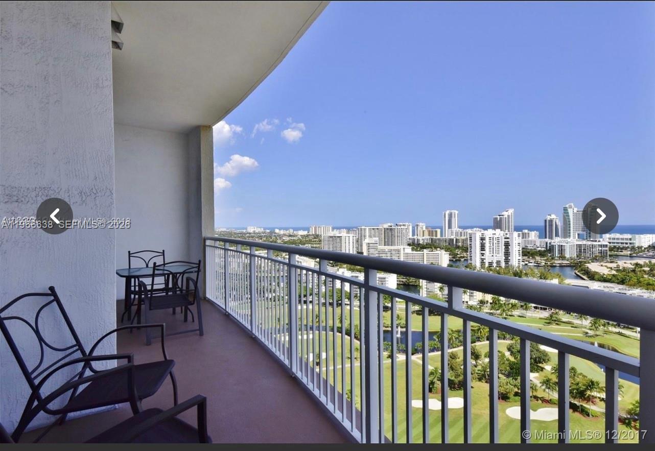 A balcony with metal chairs and a table overlooks a golf course and city skyline — 1755 E Hallandale Beach Blvd # 2505E, Hallandale Beach FL 33009, HALLANDALE BEACH, FL