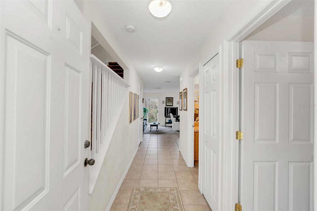 A tiled hallway leads from an entryway toward a living area with a sliding glass door — 1209 W 6TH STREET, SANFORD, FL