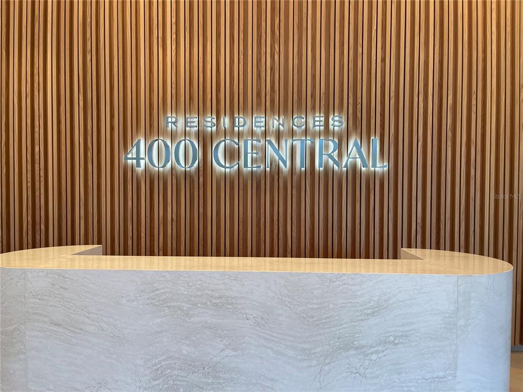 A reception desk with a marble front sits before a wall of vertical wood slats — 400 CENTRAL AVE UNIT 606, ST PETERSBURG, FL
