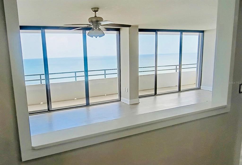 A room with light-colored flooring features large sliding glass doors opening to an oceanfront balcony — 1601 N CENTRAL AVENUE UNIT 1101, FLAGLER BEACH, FL