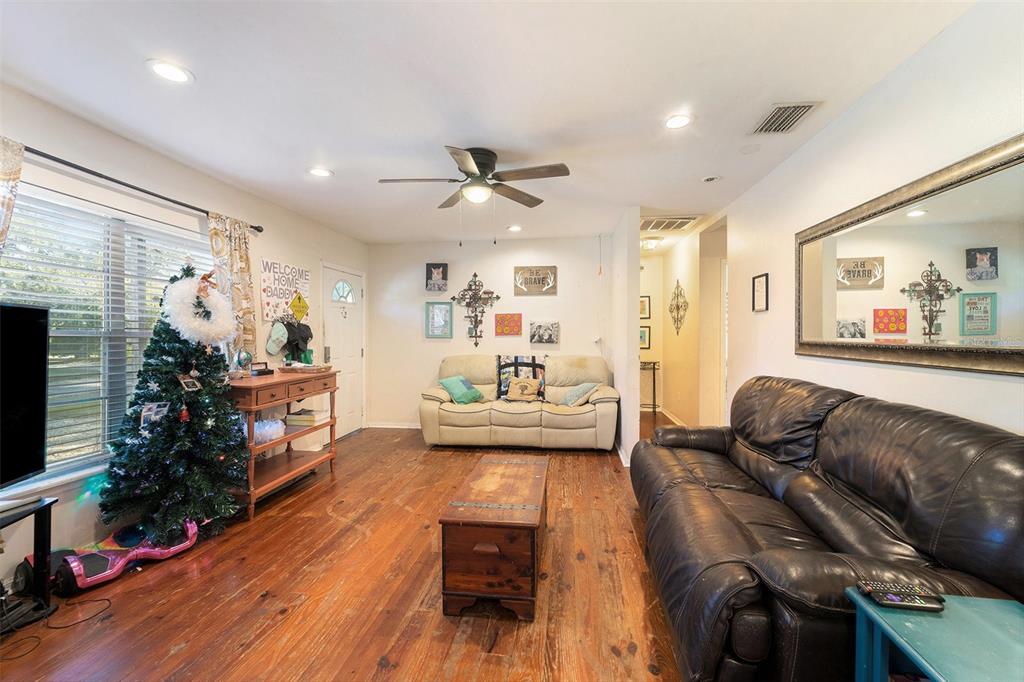 A living room features hardwood floors, a ceiling fan, two sofas, and a Christmas tree — 2215 WALLACE ROAD, LUTZ, FL