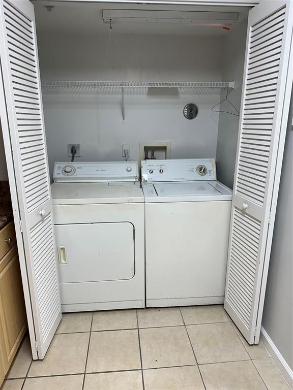 A laundry closet contains a white washer and dryer beneath a wire shelf — 529 E Sheridan Street # 1081, Dania Beach FL 33004, DANIA BEACH, FL