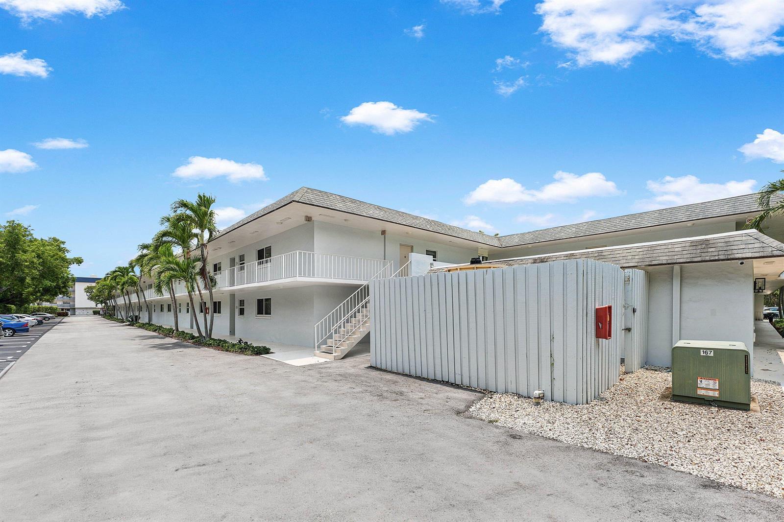 A two-story apartment building with exterior walkways, stairs, and a parking lot — 207 Tropic Isle Drive # 2050, Delray Beach FL 33483, DELRAY BEACH, FL