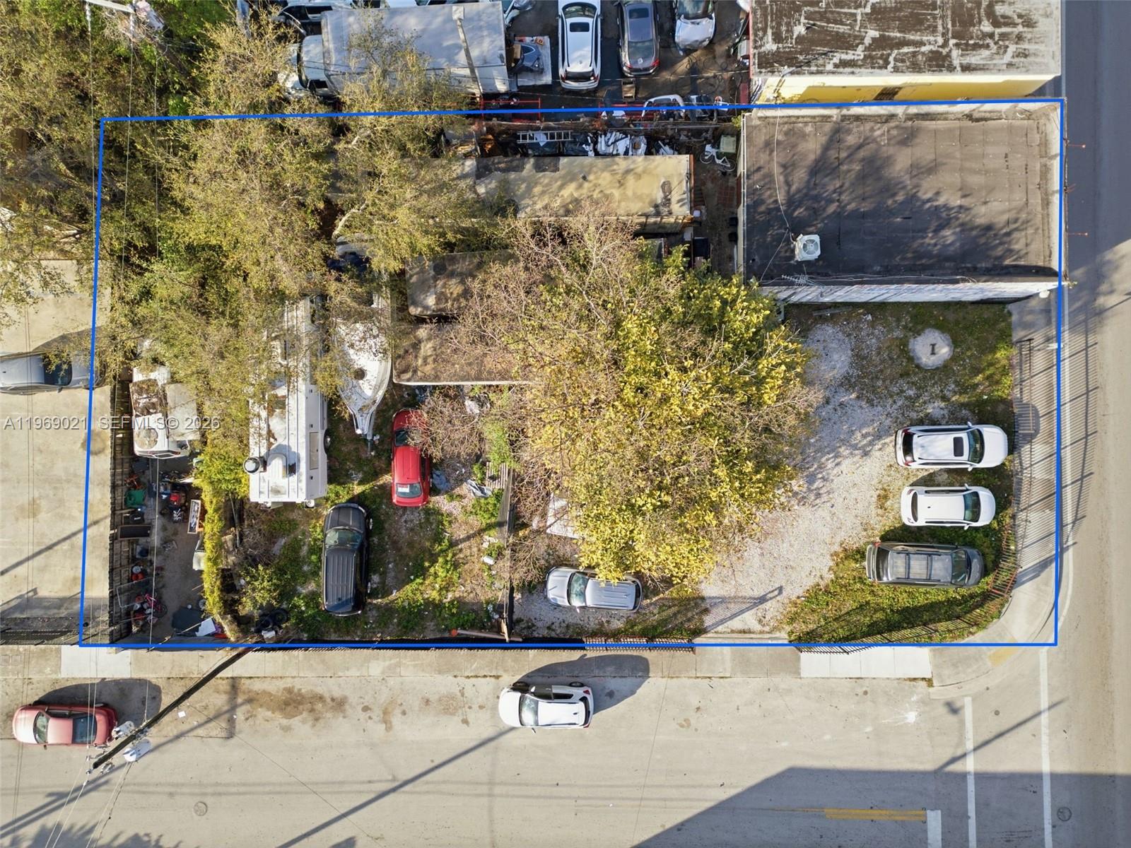 An aerial view shows a fenced lot with a building, several vehicles, and trees — 7004 NW 7th Ave, Miami FL 33150, MIAMI, FL
