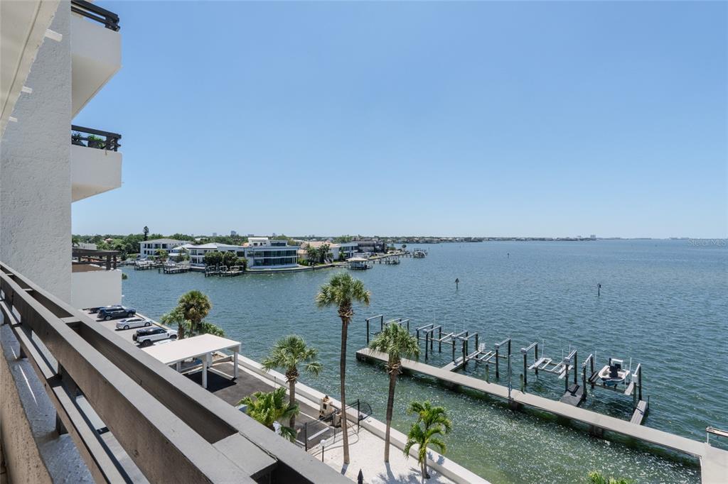 An elevated view from a balcony overlooking a bay with boat docks and palm trees — 5700 MARINER STREET UNIT 503A, TAMPA, FL