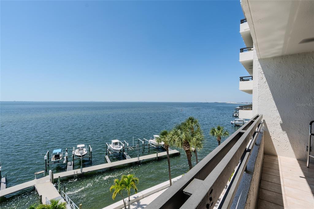 A high-angle view of a balcony overlooking a bay with boat docks and palm trees — 5700 MARINER STREET UNIT 503A, TAMPA, FL