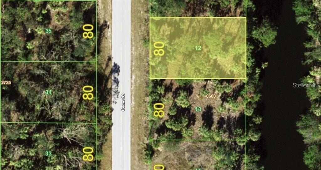This is an aerial map showing a rectangular plot of land highlighted in yellow — 3100 COMO STREET, PORT CHARLOTTE, FL
