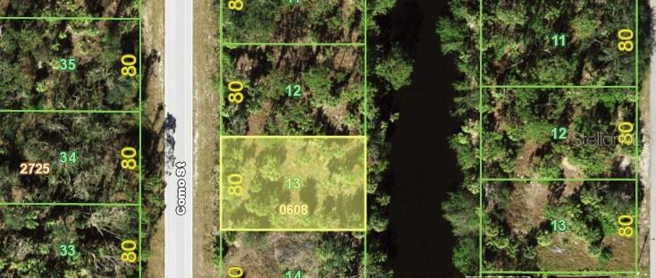 This aerial map shows a rectangular vacant lot highlighted in yellow along a paved road — 3100 COMO STREET, PORT CHARLOTTE, FL