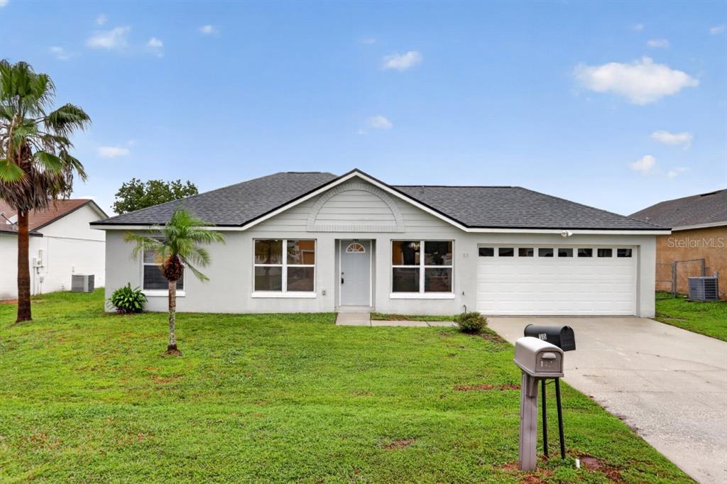 A single-story house with a gray exterior, a two-car garage, and a front lawn — 145 DORCHESTER COURT, KISSIMMEE, FL