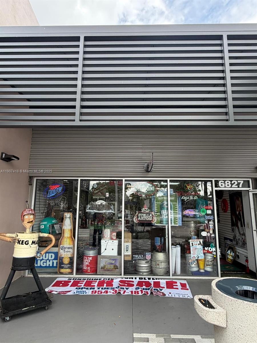 The exterior of a retail storefront features large glass windows displaying beer signage and kegs — 6827 Stirling, Davie FL 33314, DAVIE, FL