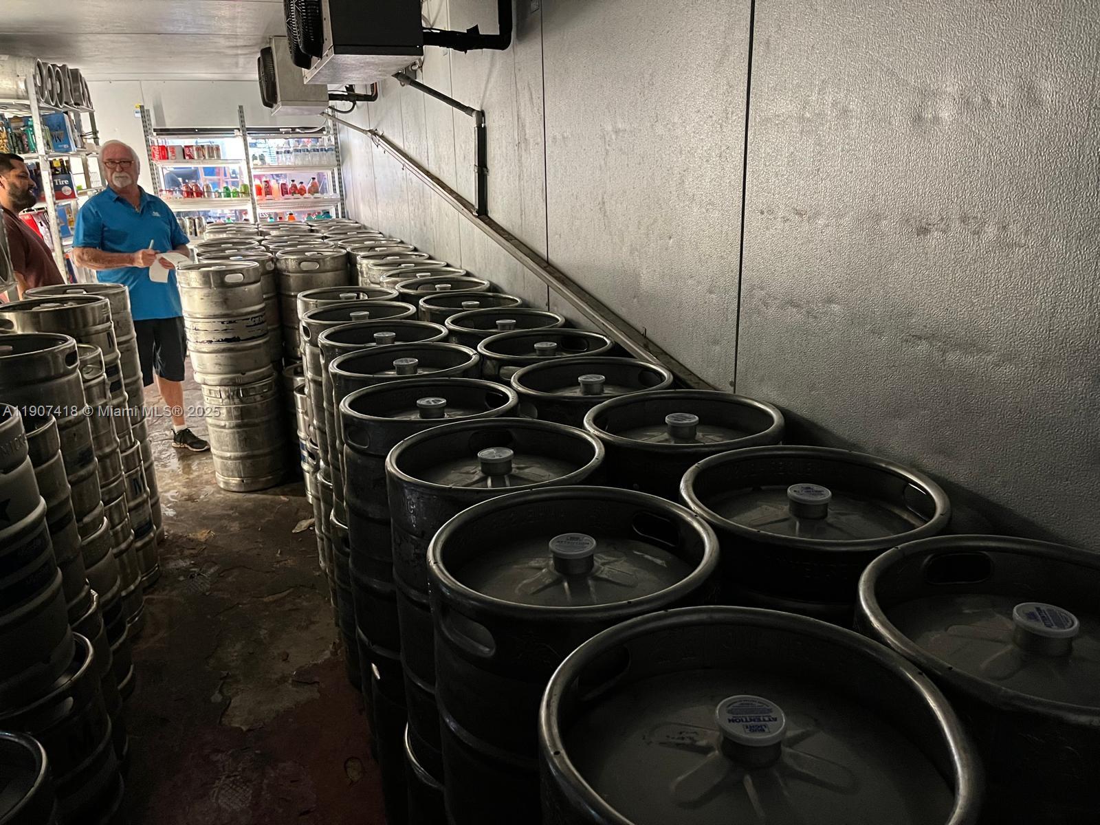 A walk-in cooler contains numerous stacked metal beer kegs and shelving units — 6827 Stirling, Davie FL 33314, DAVIE, FL