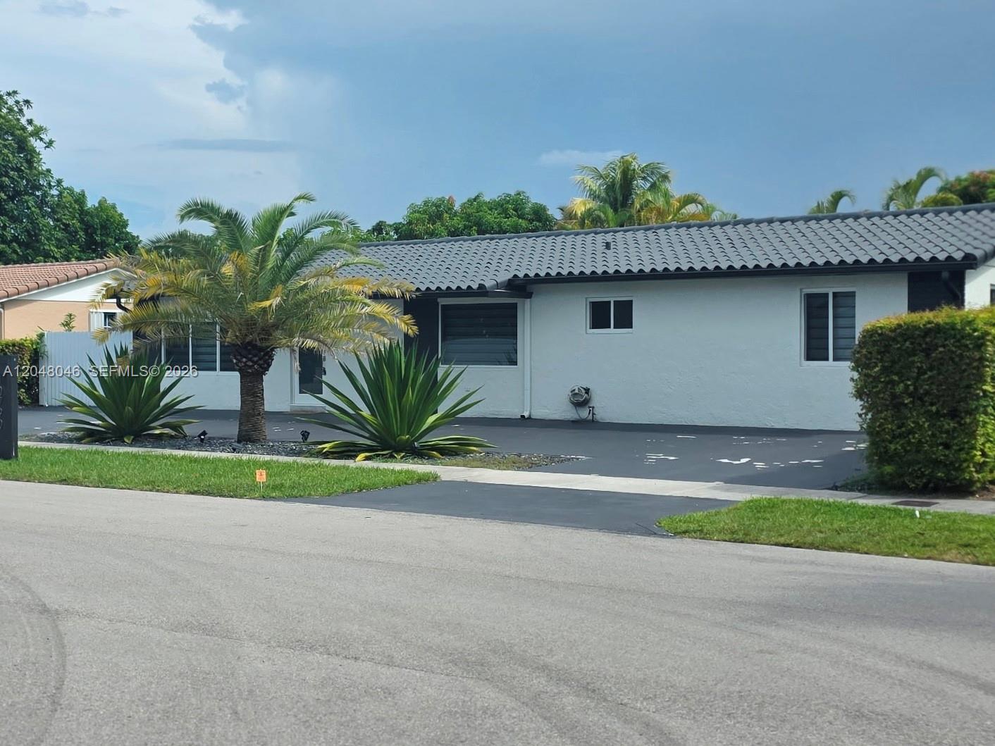A single-story house with a dark tiled roof, white stucco walls, and a paved driveway — 10790 SW 66th Dr # 0, Miami FL 33173, MIAMI, FL