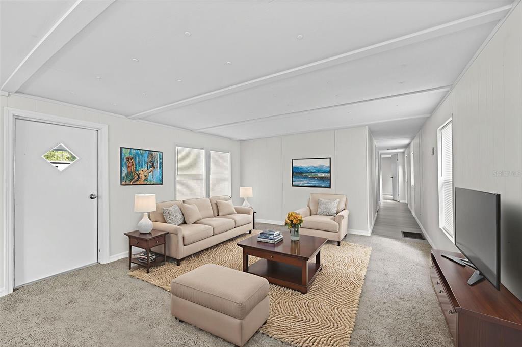 A living room features a beige sofa, armchair, ottoman, coffee table, and a television — 8061 W ROSELLA COURT, CRYSTAL RIVER, FL