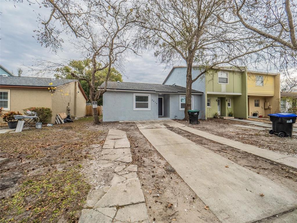A single-story light blue house with a concrete driveway and a stone walkway — 2419 RIO PINAR LAKES BOULEVARD, ORLANDO, FL
