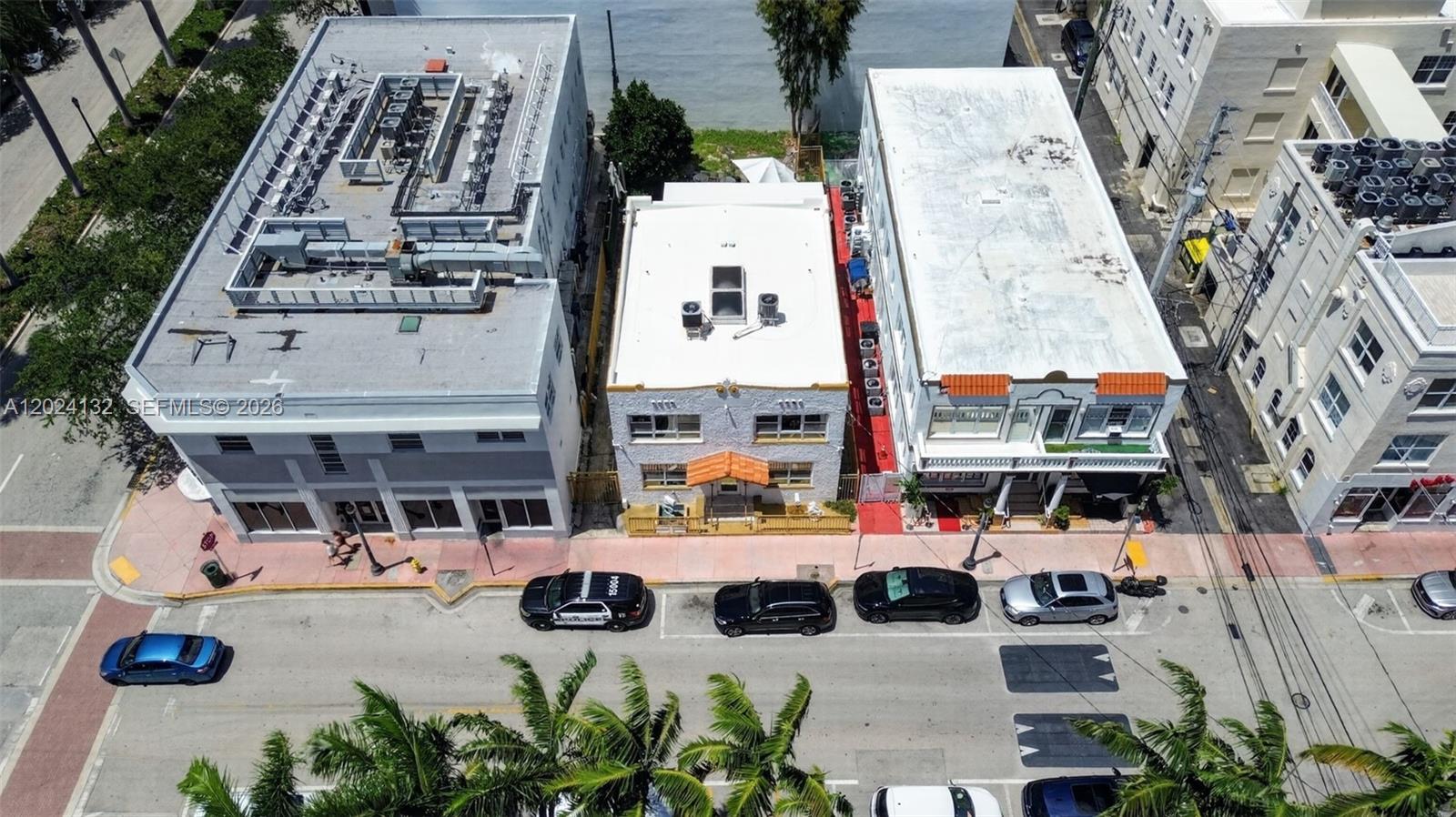 An aerial view shows three adjacent buildings along a street with parked cars — 233 1st St, Miami Beach FL 33139, MIAMI BEACH, FL
