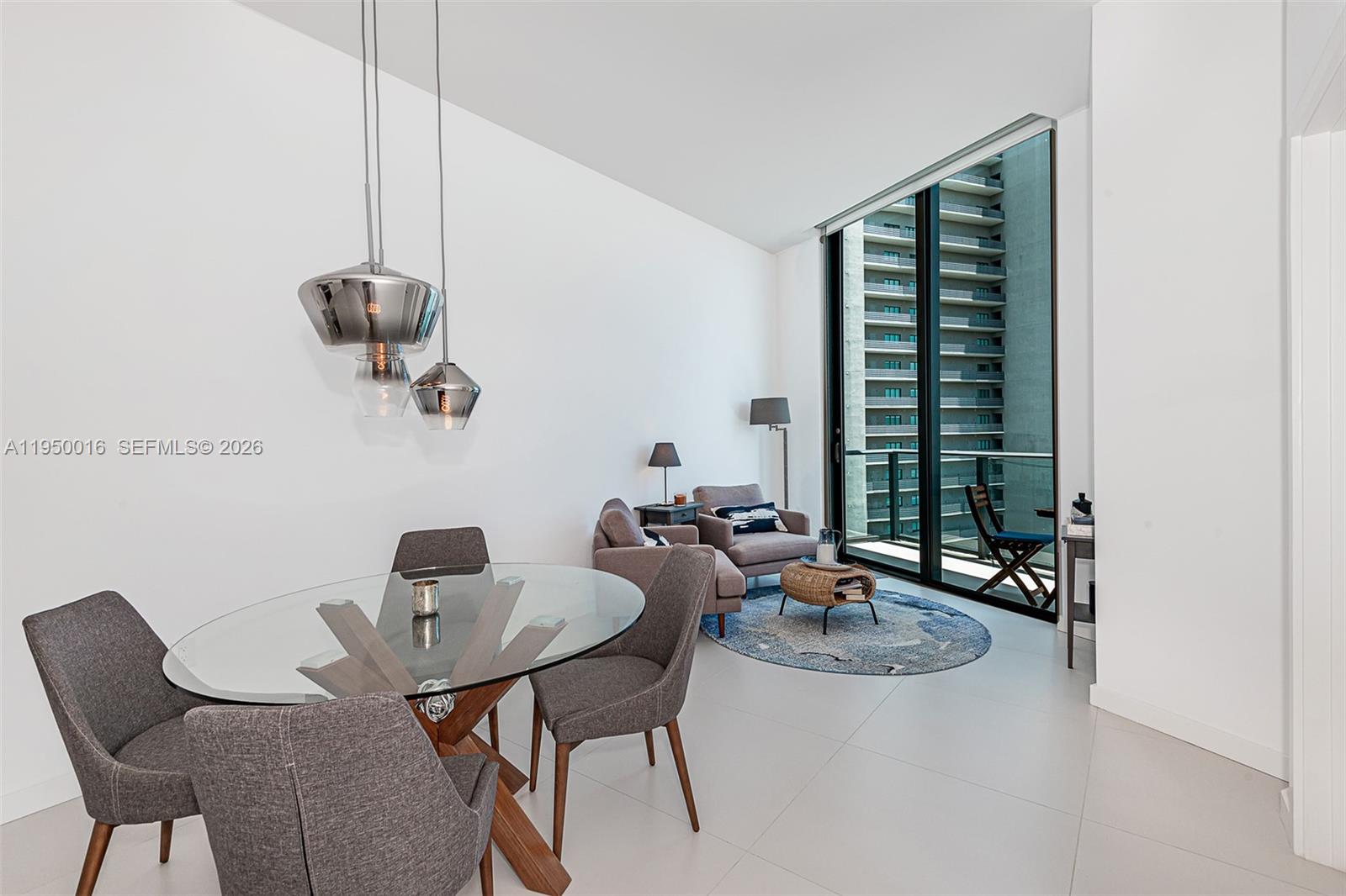 A dining area and living space feature a glass table, gray chairs, and balcony access — 501 NE 31st St, Miami FL 33137, MIAMI, FL