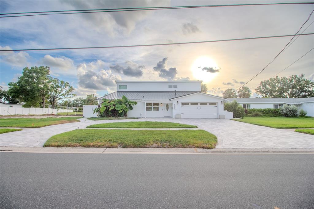 A white single-story house with a metal roof and a paved driveway faces the street — 5400 DENVER STREET NE, ST PETERSBURG, FL