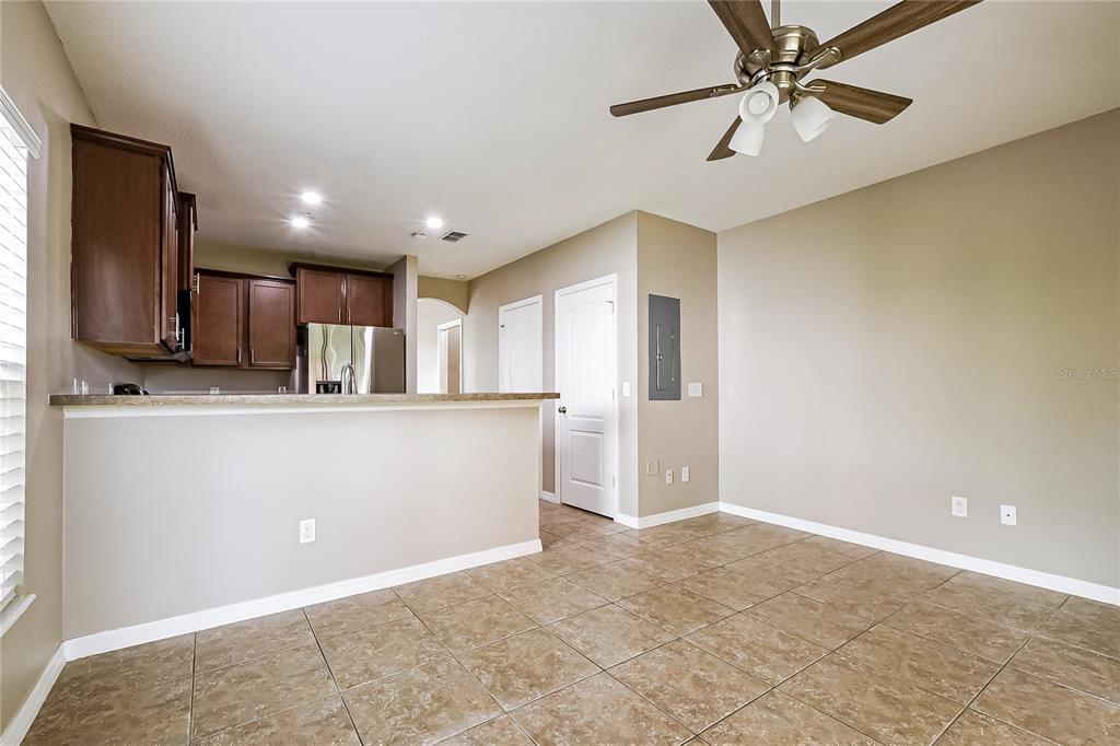 A kitchen with dark cabinets and a breakfast bar opens into a tiled dining area — 1310 WINDSOR LAKE CIRCLE, SANFORD, FL