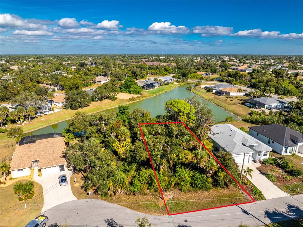 An aerial view shows a vacant, tree-covered residential lot outlined in red next to houses — 106 REBEL COURT, ROTONDA WEST, FL