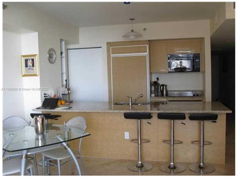A kitchen with a granite island, three bar stools, and a glass dining table — 1830 S Ocean Dr # 1505, Hallandale Beach FL 33009, HALLANDALE BEACH, FL