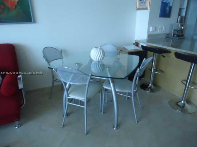A glass-topped dining table with four metal chairs sits in a room with tile flooring — 1830 S Ocean Dr # 1505, Hallandale Beach FL 33009, HALLANDALE BEACH, FL