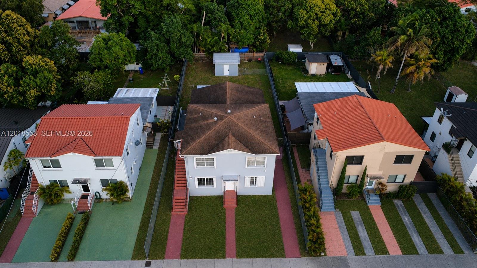 An aerial view shows three multi-story residential houses with red-tiled roofs and adjacent driveways — 111 SW 31st Ct, Miami FL 33135, MIAMI, FL