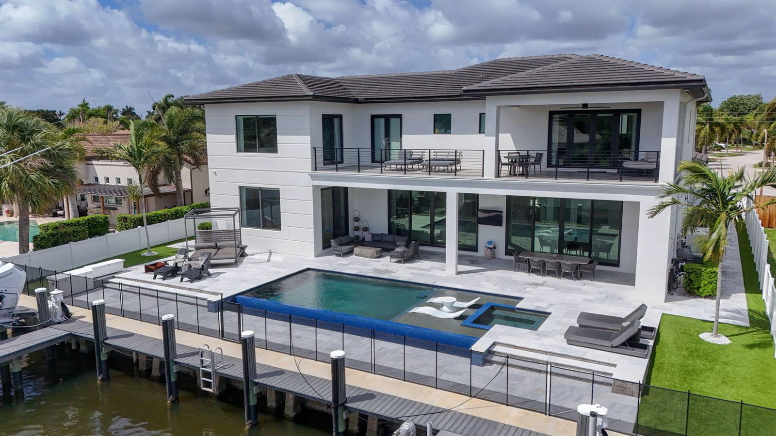 An aerial view of a two-story house with a pool, patio, and private boat dock — 824 Shore Drive, North Palm Beach FL 33408, NORTH PALM BEACH, FL