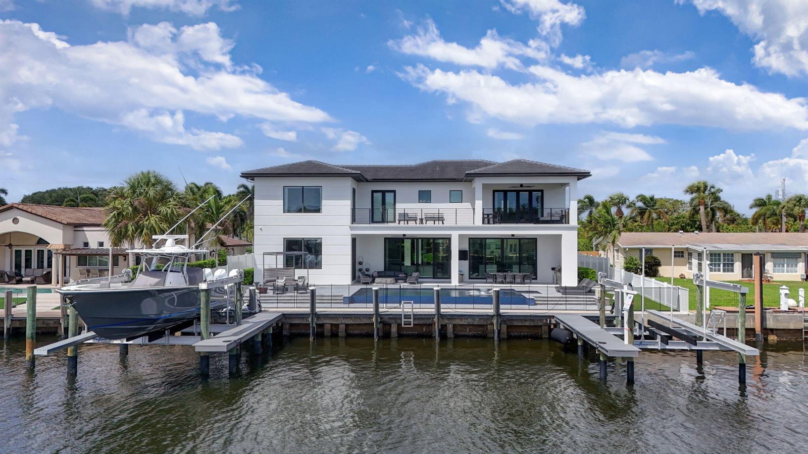 A two-story white waterfront house features a swimming pool, a boat lift, and a dock — 824 Shore Drive, North Palm Beach FL 33408, NORTH PALM BEACH, FL