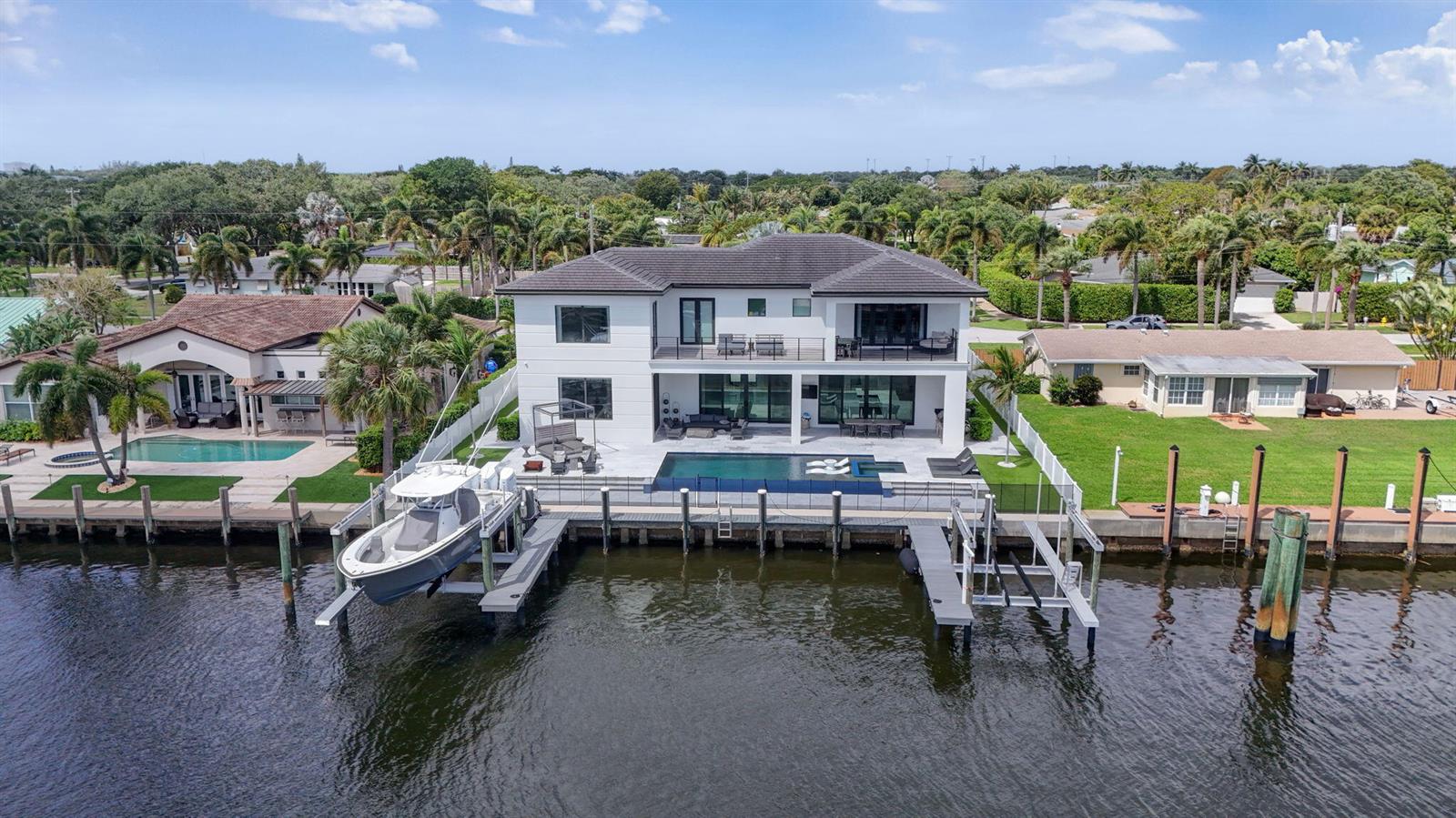 An aerial view of a two-story waterfront house with a swimming pool and boat lift — 824 Shore Drive, North Palm Beach FL 33408, NORTH PALM BEACH, FL