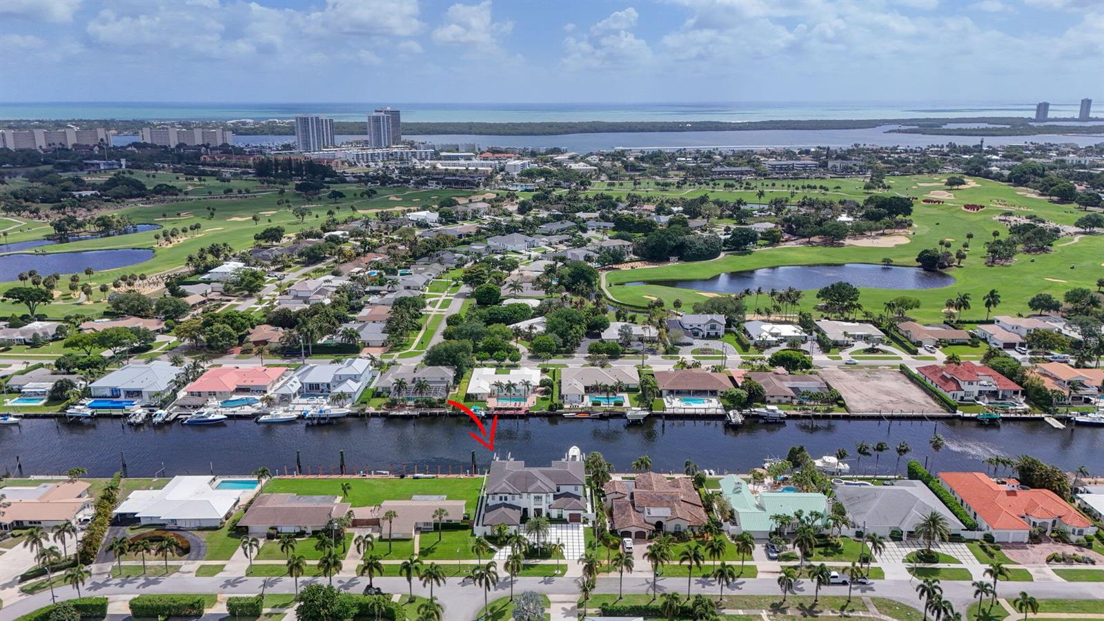 An aerial view shows a waterfront house with a pool and dock along a canal — 824 Shore Drive, North Palm Beach FL 33408, NORTH PALM BEACH, FL