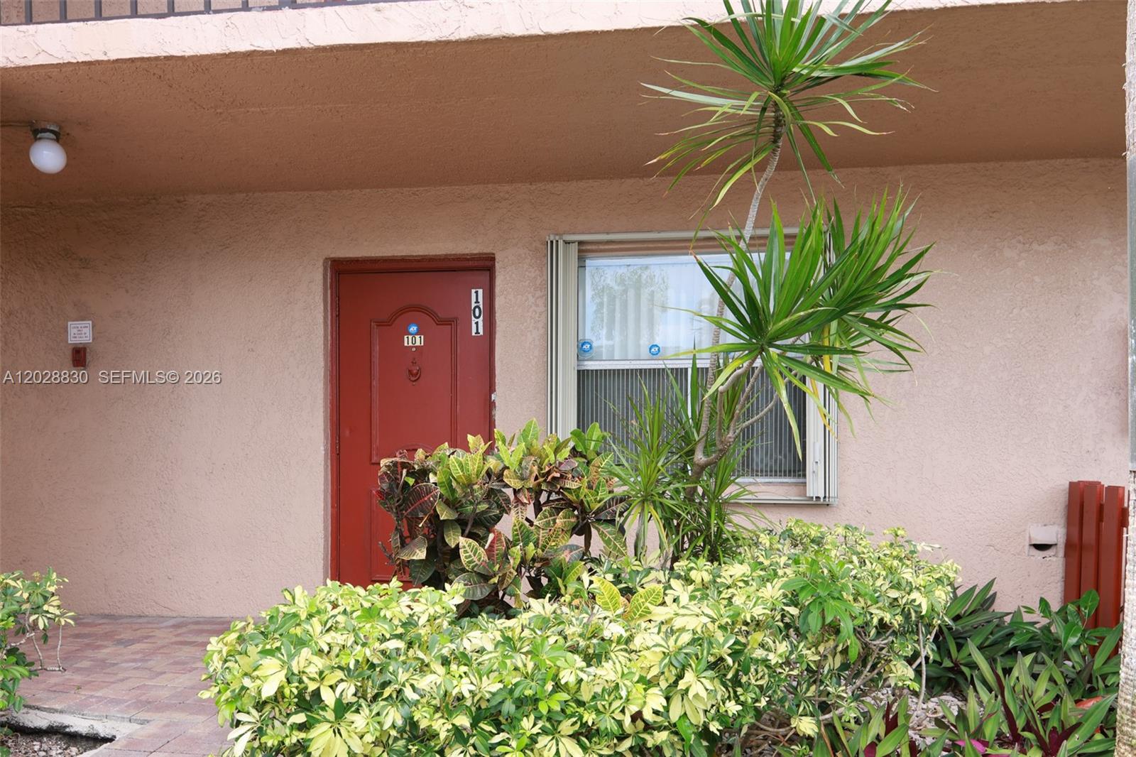 The exterior of a residential unit features a red front door labeled 101 — 7220 Lake Cir Dr # 101, Margate FL 33063, MARGATE, FL