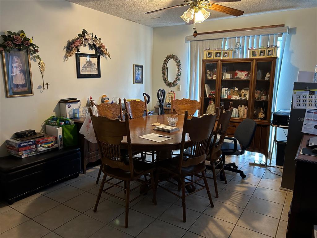 A dining room features a wooden table with chairs, a hutch, and tile flooring — 5405 1ST STREET NE, ST PETERSBURG, FL