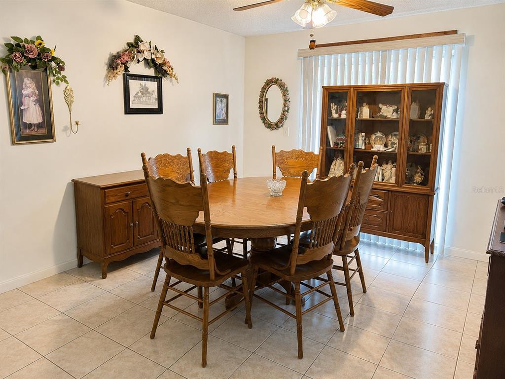 A dining room features a wooden table with six chairs, a hutch, and tile flooring — 5405 1ST STREET NE, ST PETERSBURG, FL