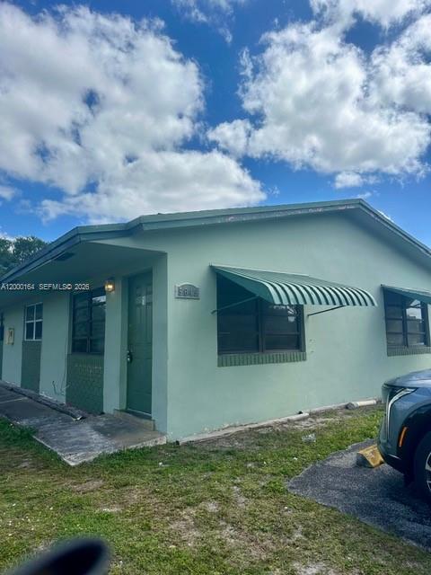 A light green, single-story house features a metal awning over a window and a door — 5649 SW 27th St # 1, West Park FL 33023, WEST PARK, FL
