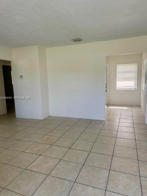 An interior view of a room with light-colored tile flooring and white walls — 5649 SW 27th St # 1, West Park FL 33023, WEST PARK, FL