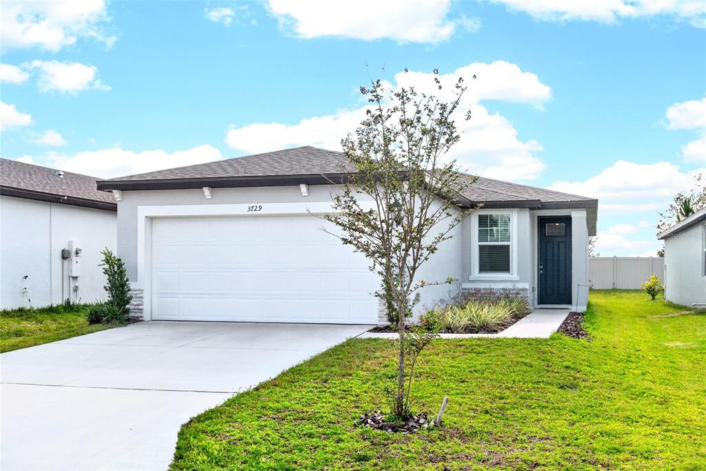 A single-story house with a white stucco exterior, a two-car garage, and a front lawn — 3729 RADIANT MOUNTAIN DRIVE, PLANT CITY, FL