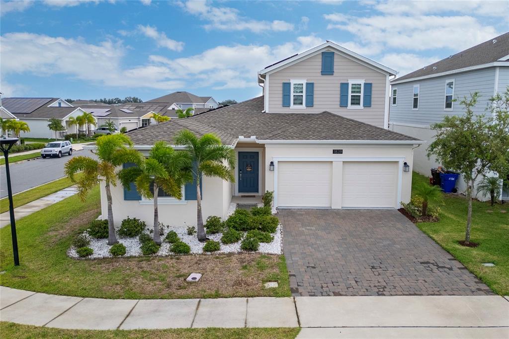 A two-story suburban house features a paved driveway, a two-car garage, and palm trees — 1839 GOOD NEIGHBOR LOOP, KISSIMMEE, FL
