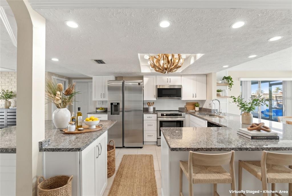 A kitchen features white cabinets, granite countertops, stainless steel appliances, and a central island — 3939 RUDDER WAY, NEW PORT RICHEY, FL