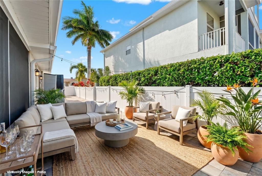 A virtually staged patio features a sectional sofa, two armchairs, and a round coffee table — 3939 RUDDER WAY, NEW PORT RICHEY, FL