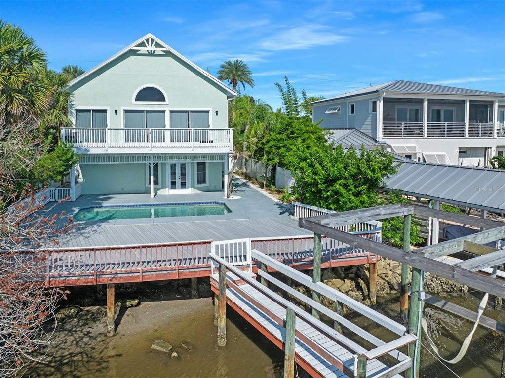 A waterfront house features a swimming pool, a wooden deck, and a private boat dock — 3110 JOHN ANDERSON DRIVE, ORMOND BEACH, FL