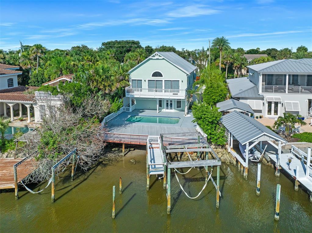 An aerial view shows a light green house with a pool, deck, and boat dock — 3110 JOHN ANDERSON DRIVE, ORMOND BEACH, FL