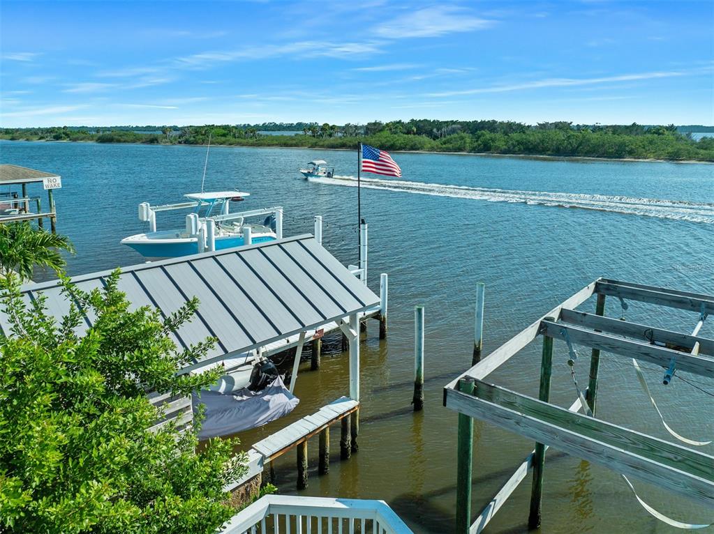 A view of a boat dock with a covered slip and a boat on the water — 3110 JOHN ANDERSON DRIVE, ORMOND BEACH, FL